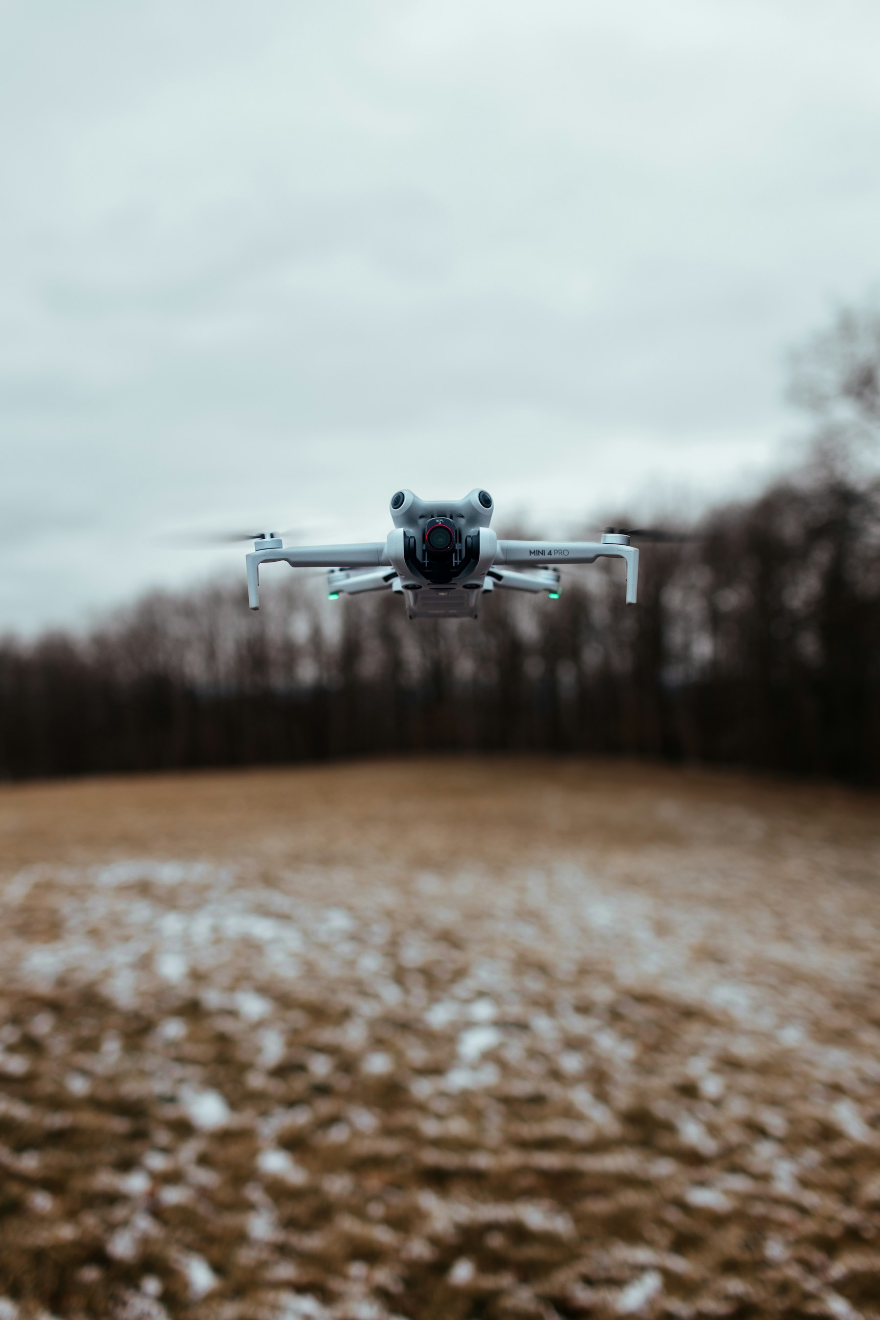 A commercial drone flying above a green field